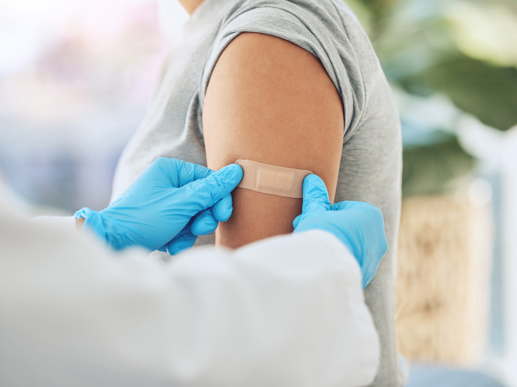 Covid virus vaccination, vaccine and doctor hands with plaster on patient arm in a medical hospital or clinic. Healthcare worker help, trust and safety flu shot antigen for protection against disease